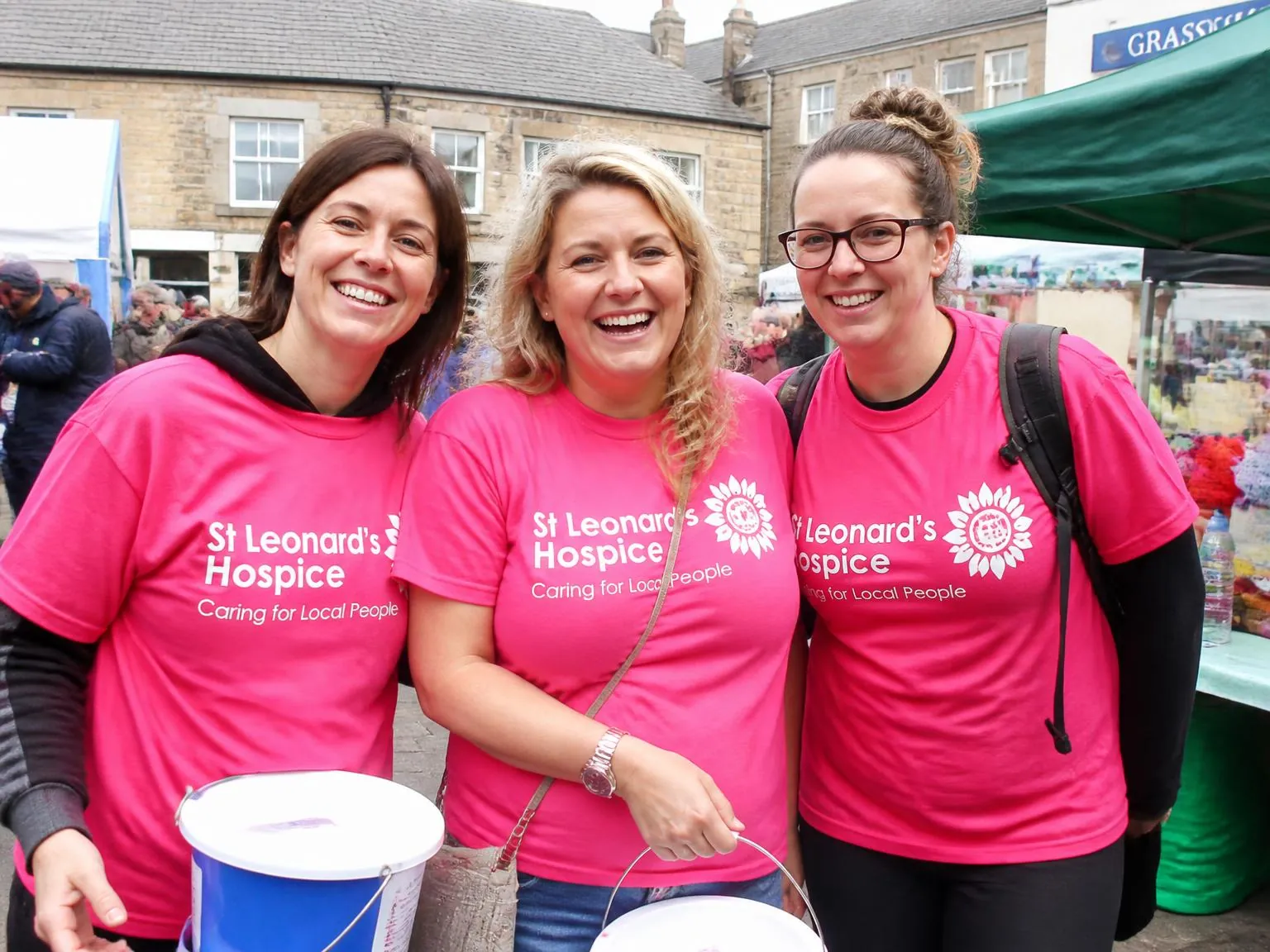 Charity volunteers in branded t-shirts packing food boxes at a North Yorkshire community event.