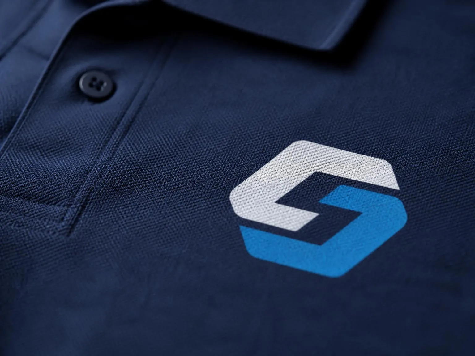 Close-up of a screen-printed logo on a navy branded workwear polo shirt.