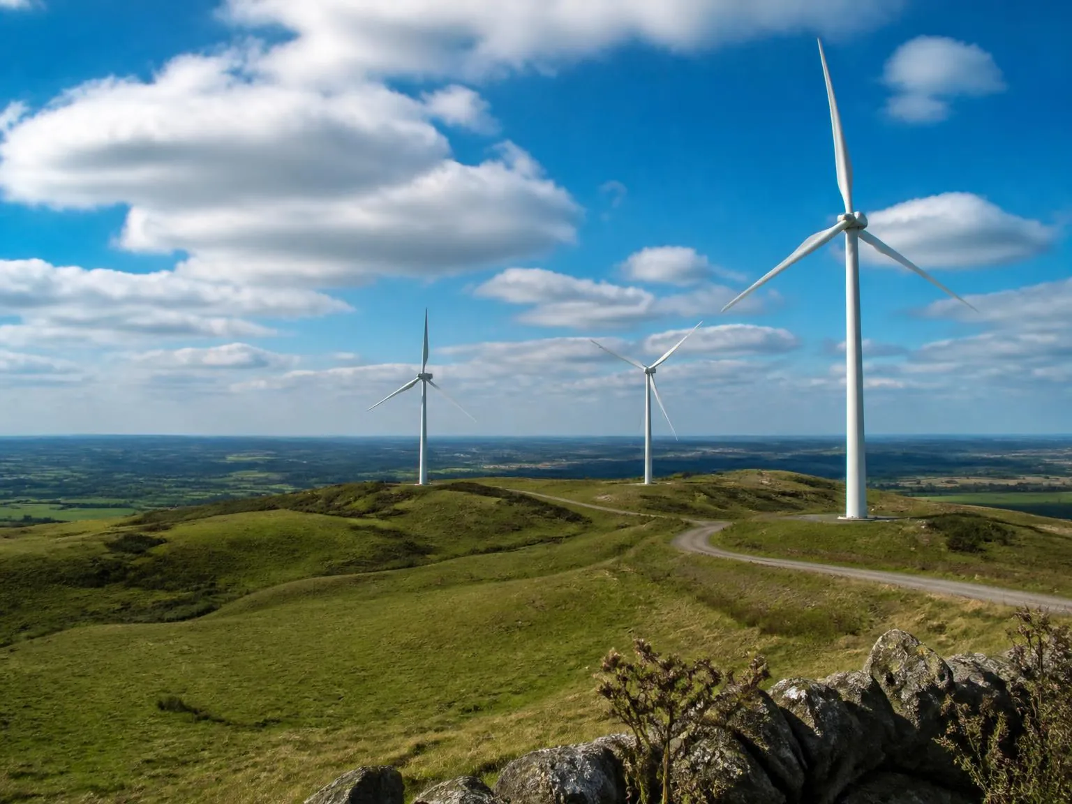 Wind turbines on Yorkshire hills representing the renewable energy powering Net-workwear production.